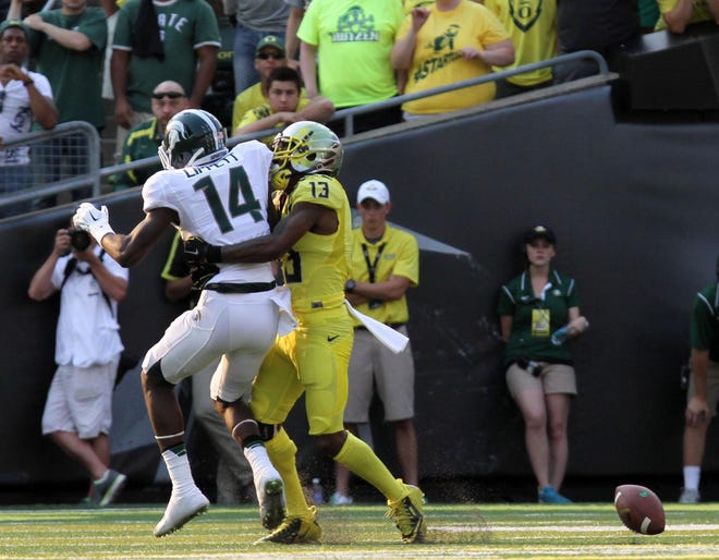 Oregon's Troy Hill (#13) tackles Michigan State's Chris Laneaux (#14) during the Ducks' match-up against the Spartans' at Autzen Stadium on Saturday, September 6, 2014. (Alan Sylvestre/The Register-Guard)