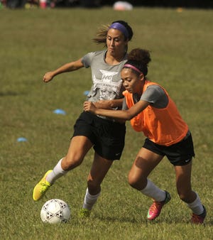 Morgan Morocco and Sienna Hoagland during Friday's practice at Holy Cross High School.