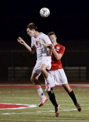 Moon's John Bal (8) and Peters' Sean Harrison collide while going up for a header during Moon's 2-0 loss to Peters Township on Tuesday,  September 9, 2014, at Moon Area High School.