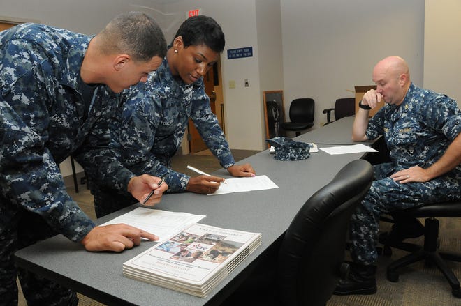 Engineman 2nd Class John Diaz and Quartermaster 3rd Class Sharlaysha Powers go through a check list during Naval Station Mayport's Combined Federal Campaign (CFC) kick off event Monday in Building One. Command CFC coordinators picked up materials to distribute during this year's campaign season.