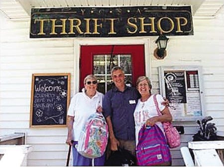 Co-chairs Mary Behnke and Bonnie Kerrick present backpacks from the Trinity Church Service Guild's annual "Back to School" drive to York Community Service Association Thrift Store Manager Donald Martin.