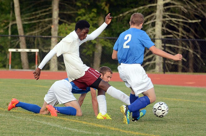 Killingly's Titus Kamara scores his first goal by getting around Putnam's Nate Lowell, right, and Mitchell Cristofori Wednesday during their game in Killingly. Killingly won, 6-1. Photos by John Shishmanian/ NorwichBulletin.com