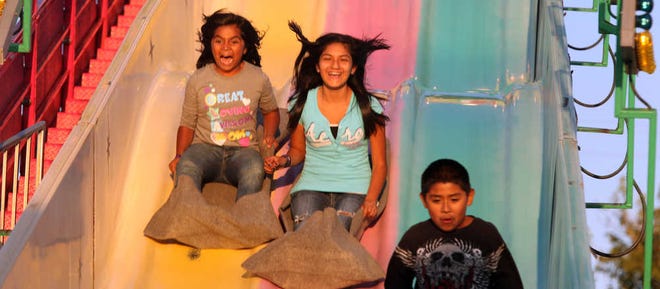 Nautia Castuneda, 8, left, Deziree Adams, 13, and Paul Rosales Jr., 10, hit the slide at the Panhandle-South Plains Fair in 2011.