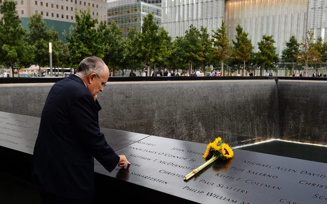 Former New York City Mayor Rudolph Giuliani stands at the edge of the North Pool during memorial observances on the 13th anniversary of the Sept. 11 terror attacks on the World Trade Center in New York, Thursday, Sept. 11, 2014. In New York, family members of those killed at the World Trade Center will read the names of the victims at a ceremony at ground zero.