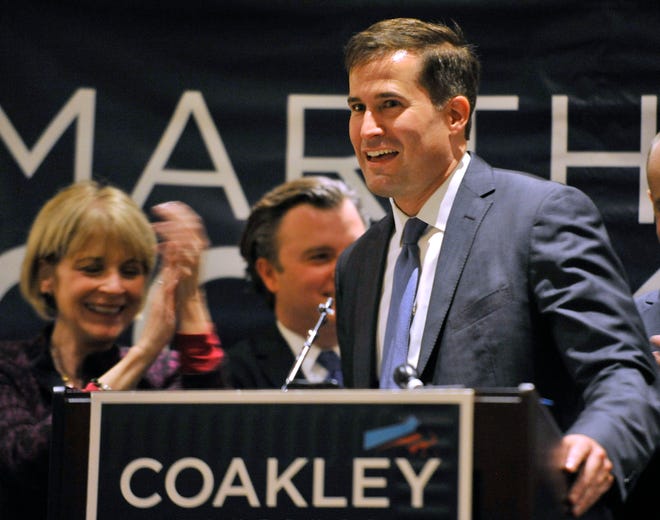 Democrat gubernatorial nominee, state Attorney General Martha Coakley, left, applauds Seth Moulton at the party's unity breakfast Wednesday, Sept. 10, 2014, in Boston. Moulton defeated incumbent U.S. Rep. John Tierney to win the party nomination in Tuesday's 6th Congressional District primary.