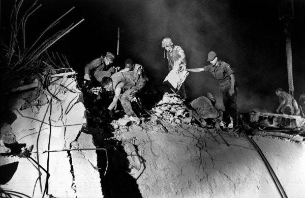 U.S. Marines and an Italian soldier, right, search through the rubble after the Oct. 23, 1983, suicide car bomb attack against the U.S. Marine barracks in Beirut, Lebanon. Some analysts say the U.S. conflict with factions of Islamist militants and terrorists dates back further than the autumn of 2001.