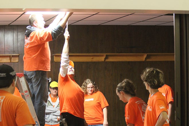 Home Depot employees work on light fixtures at the Coldwater American Legion. CHRIS WORST PHOTO