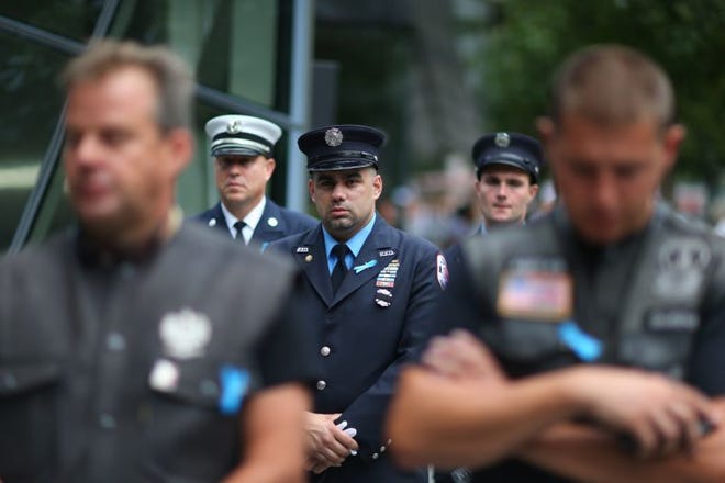Members of the FDNY observe a moment of silence yesterday morning during memorial observances on the 13th anniversary of the Sept. 11 terror attacks.