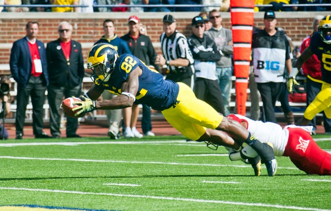 Michigan wide receiver Amara Darboh (82) dives for a touchdown, defended by Miami (Ohio) defensive back Quinten Rollins (2) in the first quarter of an NCAA college football game in Ann Arbor, Mich., Saturday, Sept. 13, 2014. (AP Photo/Tony Ding)