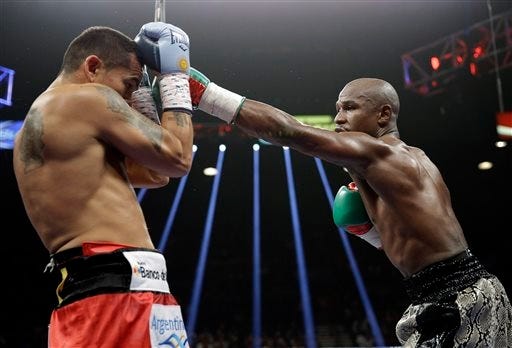 Floyd Mayweather punches Marcos Maidana, left, during their WBA welterweight and WBC super welterweight title fight, Saturday, Sept. 13, 2014, in Las Vegas.