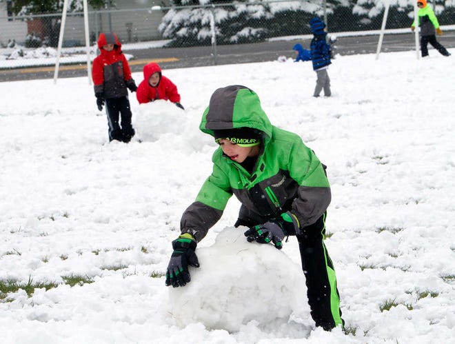 In this Thursday, Sept. 11, 2014 photo, Livingston Elementary second-grader Carter Thompson enjoys playing in the snow with classmates during recess in Cody, Wyo. A late summer snowstorm dropped 3 to 5 inches in Cody, the earliest recorded snowfall there since records were kept in 1915. Other parts of the state received up to 20 inches of snow. (AP Photo/The Cody Enterprise, Raymond Hillegas) POWELL TRIBUNE OUT