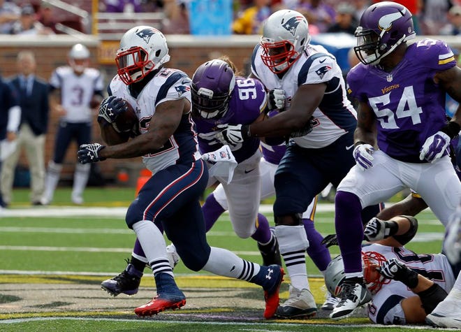 New England Patriots running back Stevan Ridley, left, runs with the ball during the fourth quarter of an NFL football game against the Minnesota Vikings Sunday, Sept. 14, 2014, in Minneapolis.
