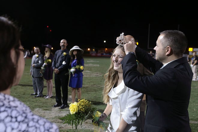 Central Lafourche High School Principal Chris Kimball (right) crowns Kourtney LeBlanc as the 2014 homecoming queen Friday during halftime of the Trojans' football game against the Joseph S. Clark Preparatory High School Bulldogs in Mathews.