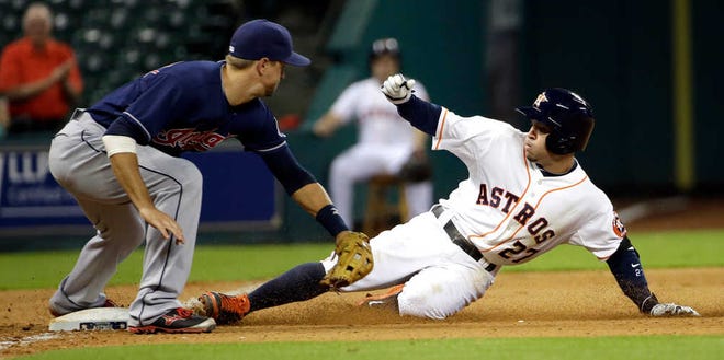 Houston Astros' Jose Altuve (27) slides safely into third with a triple as Cleveland Indians third baseman Lonnie Chisenhall reaches for the late tag during the eighth inning of a baseball game Monday, Sept. 15, 2014, in Houston. (AP Photo/David J. Phillip)