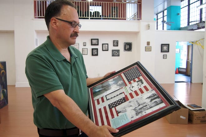 Michael Villanueva holds framed artwork of his uncle, Korean War veteran Thomas Villanueva. CALIXTRO ROMIAS/The Record