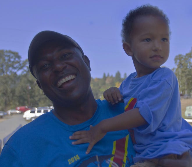 Richard Kitumba, president of the non-profit The City of Refuge International, celebrates with his son, Kaizen Kitumba, 4, after a successful Congo 5K at Dorris Ranch on Sunday, September 14, 2014. Richard was born and raised in the Democratic Republic until moving to the U.S. in his early twenties, and said that the funds raised from the event were going to be invested into some of their many water-wellness programs in Congo. (Alan Sylvestre/The Register-Guard)