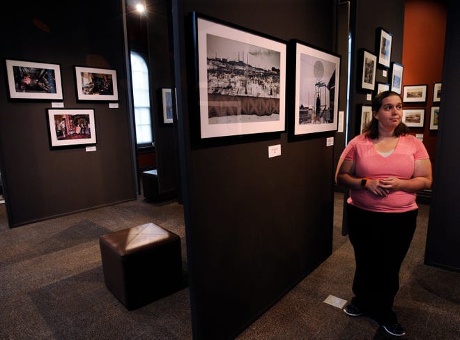 A visitor looks over photos at the exhibition "Siberia Imagined & Reimagined" at the Museum of Russian Icons in Clinton.