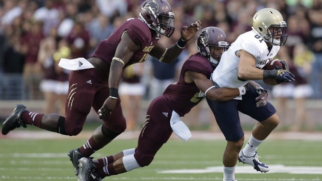 Navy’s Brendan Dudeck is hit by Texas State’s David Mims as Jerrid Jeter-Gilmon closes in after a catch during the first half of last week’s game at Bobcat Stadium. (Eric Gay/Associated Press)