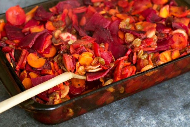 This photo shows carrot, parsnip, beet and sweet potato tsimmes. Instead of a stew texture, the recipe offers a roasted vegetable dish with a sweet sauce.