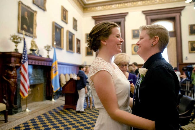 In this May 23, 2014, file photo, Corey Crawford, right, and Jessica Samph smile at each other before their wedding at City Hall in Philadelphia. While many liberal policy goals have proved elusive during Barack Obama's presidency, there have been dramatic advances for two causes that once seemed quixotic, the legalization of same-sex marriage and the decriminalization of marijuana.