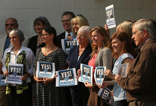 Supporters of a ballot measure asking voters to renew a local option levy that provides about $8 million a year to the Eugene School District line up for a photo during a campaign press conference at Sheldon High School. (Chris Pietsch/The Register-Guard)