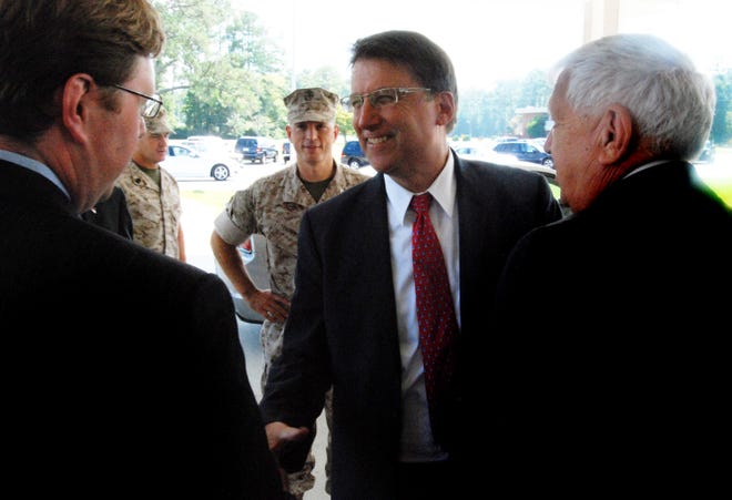 N.C. Gov. Pat McCrory speaks with James Norment, left, and Hugh Overholt as he arrived at a meeting of the North Carolina Military Affars Commission on Tuesday at Cherry Point air station. Col. Chris Pappas, commander of the base, is shown at center.