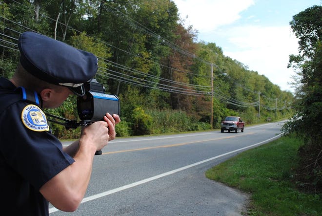 Tiverton police Officer Kurt Ripke takes aim at a vehicle with the department's new laser speed gun. The gun can record the license plate and speed of a vehicle up to a quarter-mile away.