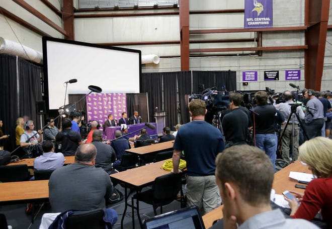 Minnesota Vikings executive vice president & general manager Rick Spielman, left, owner/chairman Mark Wilf, center, and executive vice president legal affairs Kevin Warren, right, are surrounded by media during a news conference in Eden Prairie, Minn., Wednesday, Sept. 17, 2014. Hours after reversing course and benching Adrian Peterson indefinitely, Wilf said that the team "made a mistake" in bringing back their superstar running back following his indictment on a felony child-abuse charge in Texas.(AP Photo/Ann Heisenfelt)