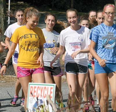 Photo by Anthony Spaulding/New Jersey Herald — North Warren’s Jenny Hovell, left, and Regina Duncan, center, laugh together as they finish a warmup run during cross country practice Monday at North Warren High School in Blairstown.