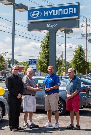 Major Hyundai received a plaque from The Church of St. John the Apostle. Pictured are Father Jeffrey Walsh, Tim Fitzgerald, Nadder Nejad, general manager of Major Hyundai accepting for Daniel Dortic and Jack Bernier.