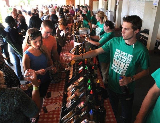 Wine server Dan Nowakowski gives samples of wine to attendees at last year's Wine Fest at Valenzano Winery in Shamong.