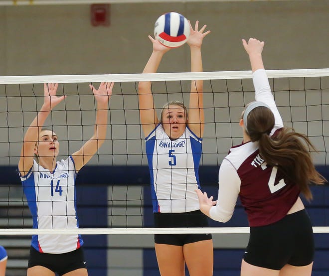 Winnacunnet's Meg Knollmeyer (left) and Alison Taylor (center) jump to block a shot by Timberlane's Caitlin Agneta during Wednesday's Division I volleyball game. Matt Parker photo