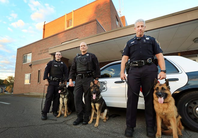 Portsmouth Police officer Steve Blanding and his K-9 "Max", left, join officer Scott Pearl with "Steel", center, as officer Eric Kinsman and "Titan", right, retire from the K-9 Unit. 

Photo by Ioanna Raptis