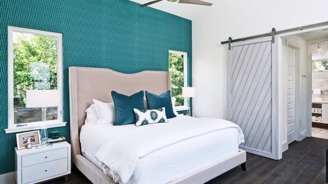 Upholstered headboards and neutral tones with pops of color in pillows or an accent wall are key bedroom trends.