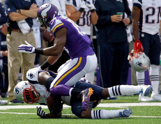 New England cornerback Darrelle Revis, bottom, falls to the turf after intercepting a pass intended for Minnesota wide receiver Greg Jennings, top, during NFL action Sunday.