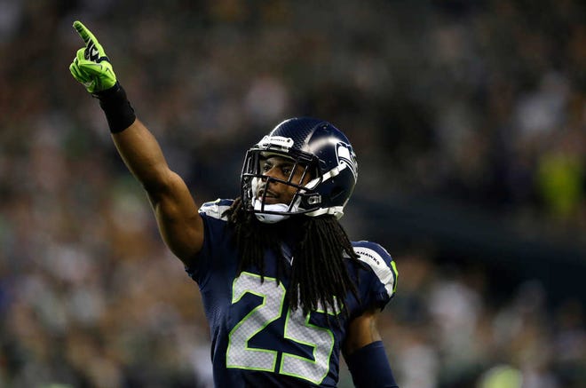 Seattle Seahawks cornerback Richard Sherman points to the crowd in the second half of an NFL football game between the Seattle Seahawks and the Green Bay Packers, Thursday, Sept. 4, 2014, in Seattle. (AP Photo/Scott Eklund)