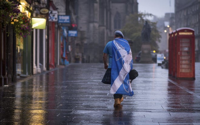 A lone YES campaign supporter walks down a street in Edinburgh after the result of the Scottish independence referendum, Scotland, Friday, Sept. 19, 2014.