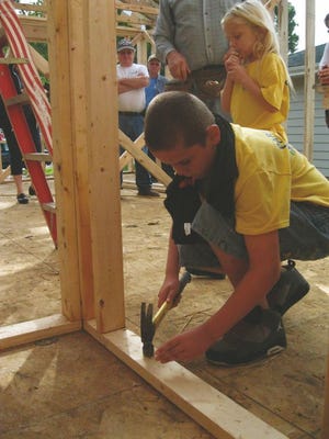 Tim Tiller pounds a nail into one of the frames of a wall in his future Habitat for Humanity home at 111 N. Norwood Place. A wall raising ceremony took place for the new home Saturday and was attended by East Peoria Mayor Dave Mingus.