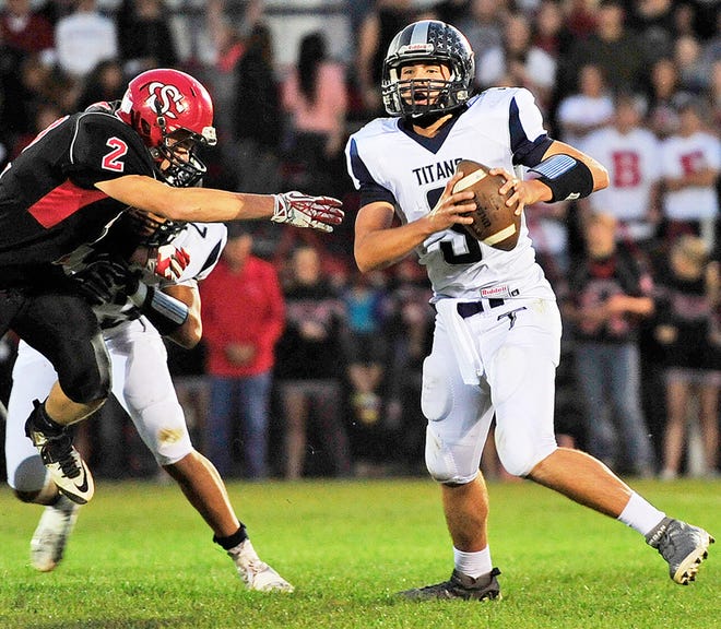 Annawan-Wethersfield quarterback Tanner Litton tries to elude the pass rush of Stark County’s John Groter (2) in Friday night’s LTC matchup in Wyoming.