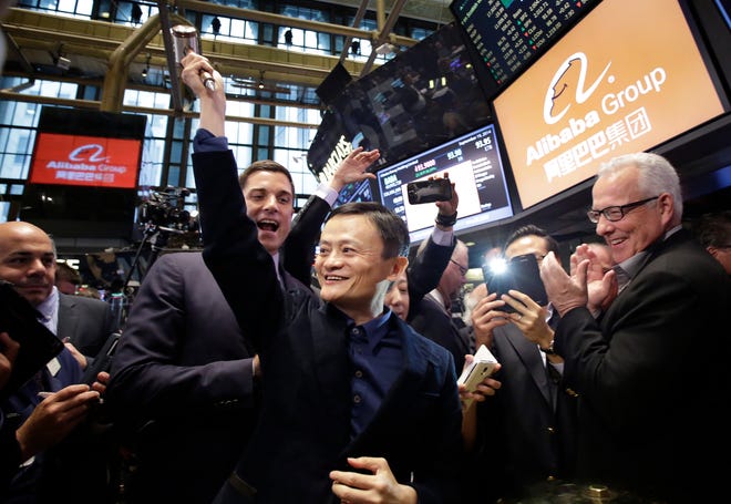 Jack Ma, center, founder of Alibaba, raises a ceremonial mallet before striking a bell during the company's IPO at the New York Stock Exchange on Friday in New York.