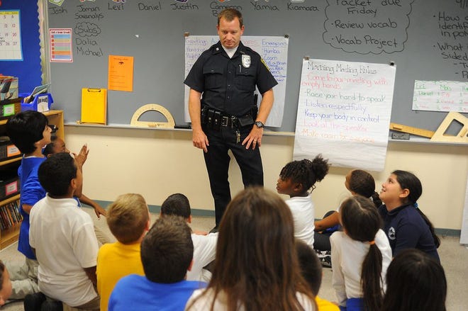 Fall River school resource officer Robert Costa talks with students during a math class at Spencer Borden Elementary School. School resource officers aim to not only keep schools safe, but also reach out to and connect with families and community members.