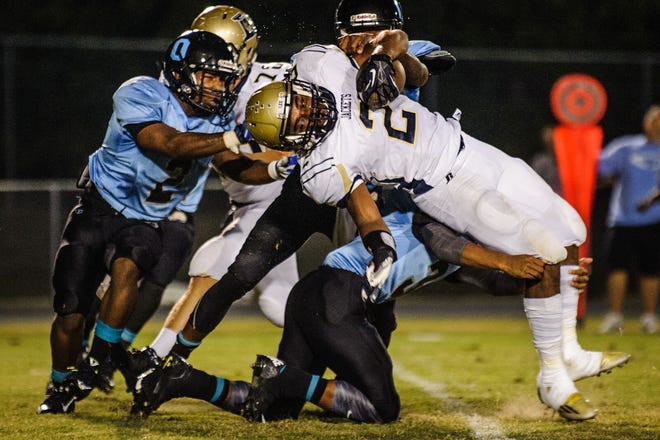 Lee County's Jerry Pullman is upended by Overhills' Anthony Faraimo during their game Friday night.
