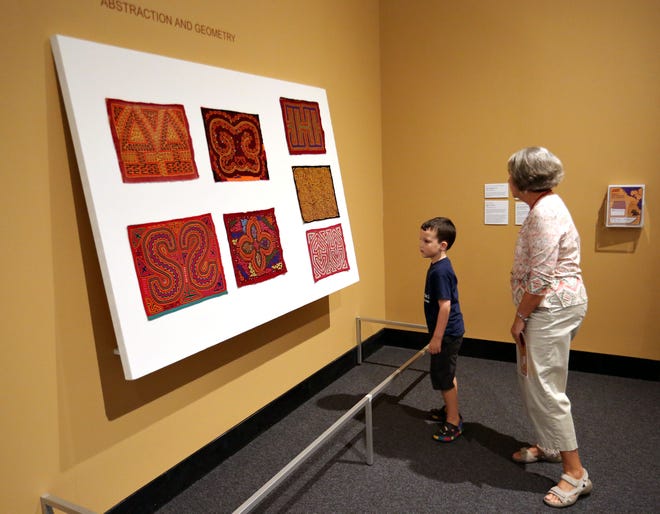Luke Gollery, 5, of Lake City, looks at some traditional molas with docent Karan Schwartz, right, during the family day exploration of the exhibition "Patterns Past and Present: Arts of Panama," at the Harn Museum of Art, in Gainesville Sept. 20, 2014.