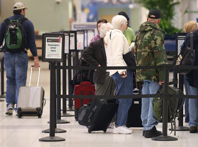 Travelers wait to go through security at the Northwest Florida Beaches International Airport.