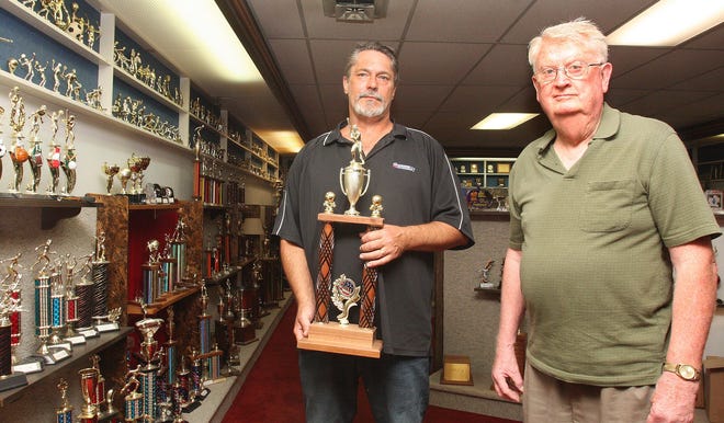 Tim Kaiser (left) and George Mawry stand in their showroom Tuesday, Aug. 19, 2014, with trophies manufactured and sold at Feico Inc. in Freeport.