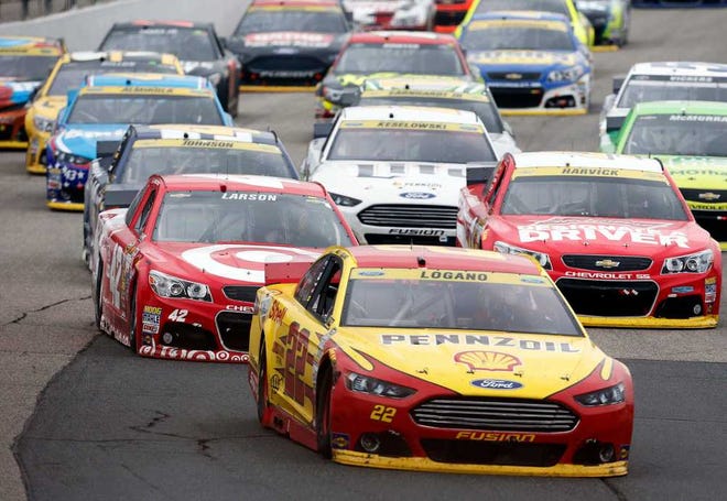Joey Logano (22) takes the lead on the final restart during the NASCAR Sprint Cup series auto race at New Hampshire Motor Speedway on Sunday, Sept. 21, 2014, in Loudon, N.H. Logano went on to win the race. (AP Photo/Jim Cole)