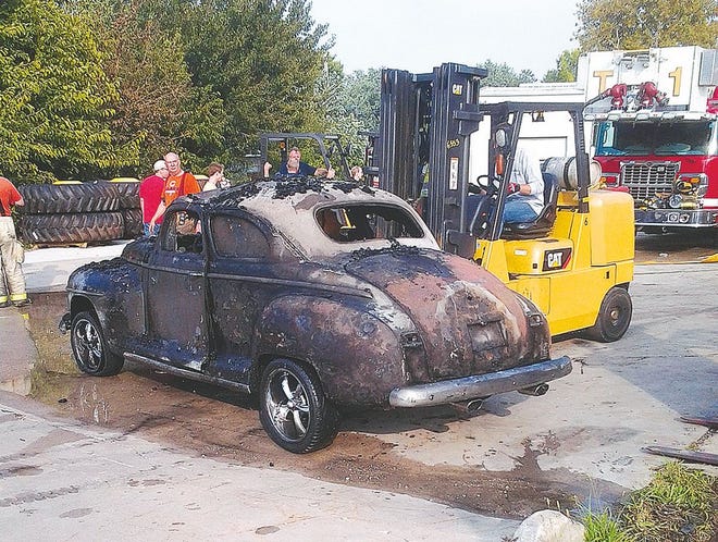 A burned car from the 1940s is removed from a storage facility following a fire in Morton. The fire Saturday destroyed the storage facility and multiple classic cars that were inside. 
Zach Berg / GateHouse Media Illinois