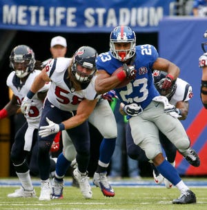 New York Giants running back Rashad Jennings (23) is tackled by the Houston Texans in the third quarter of an NFL football game, Sunday, Sept. 21, 2014, in East Rutherford, N.J. (AP Photo/Kathy Willens)