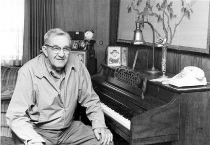 Clark Center after retirement, seated at his piano.