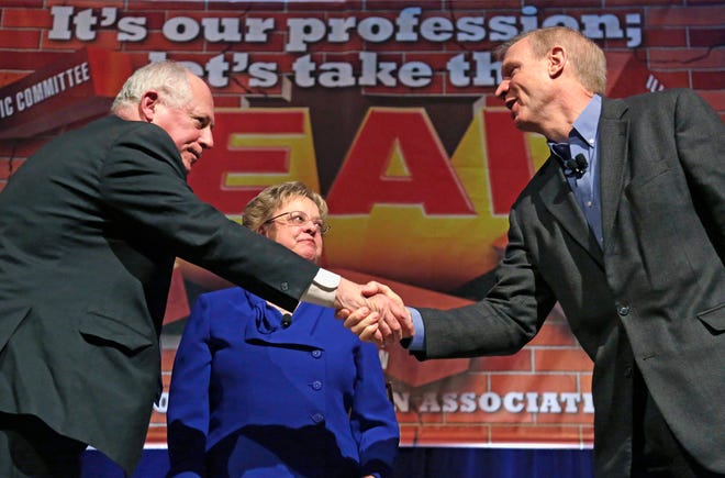In this April 11, 2014 file photo, Gov. Pat Quinn, left, and his Republican rival, venture capitalist Bruce Rauner, shake hands after they appeared together at the annual meeting of the Illinois Education Association in Chicago. (AP Photo/M. Spencer Green, File)